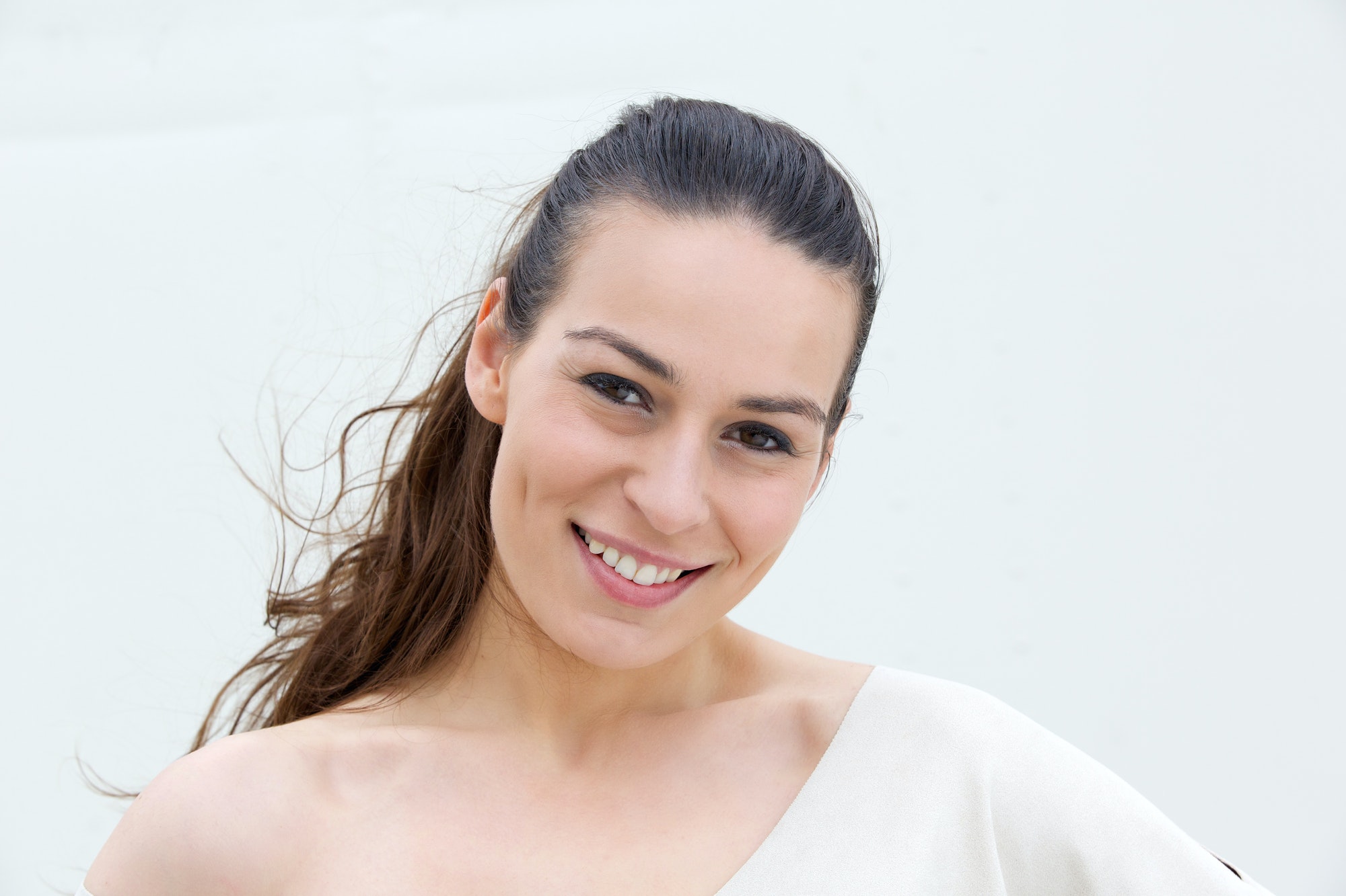 Young woman smiling on white background
